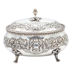 Bols en argent avec reliefs végétaux, couvercle à bouton de gland et quatre pieds découpés.