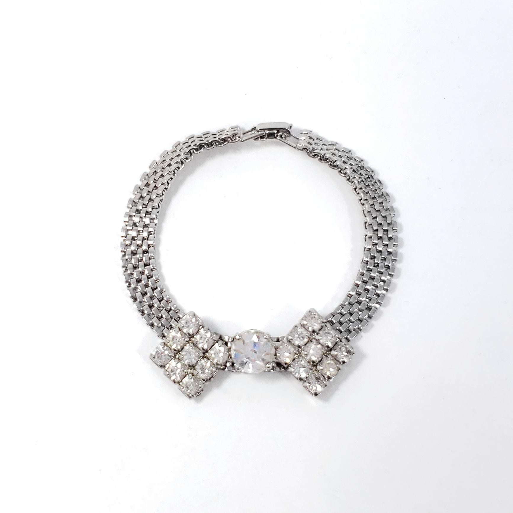A bowtie accented with clear crystals, set on a silver-tone chain bracelet. The perfect touch of retro flair!

Circa 1950s.