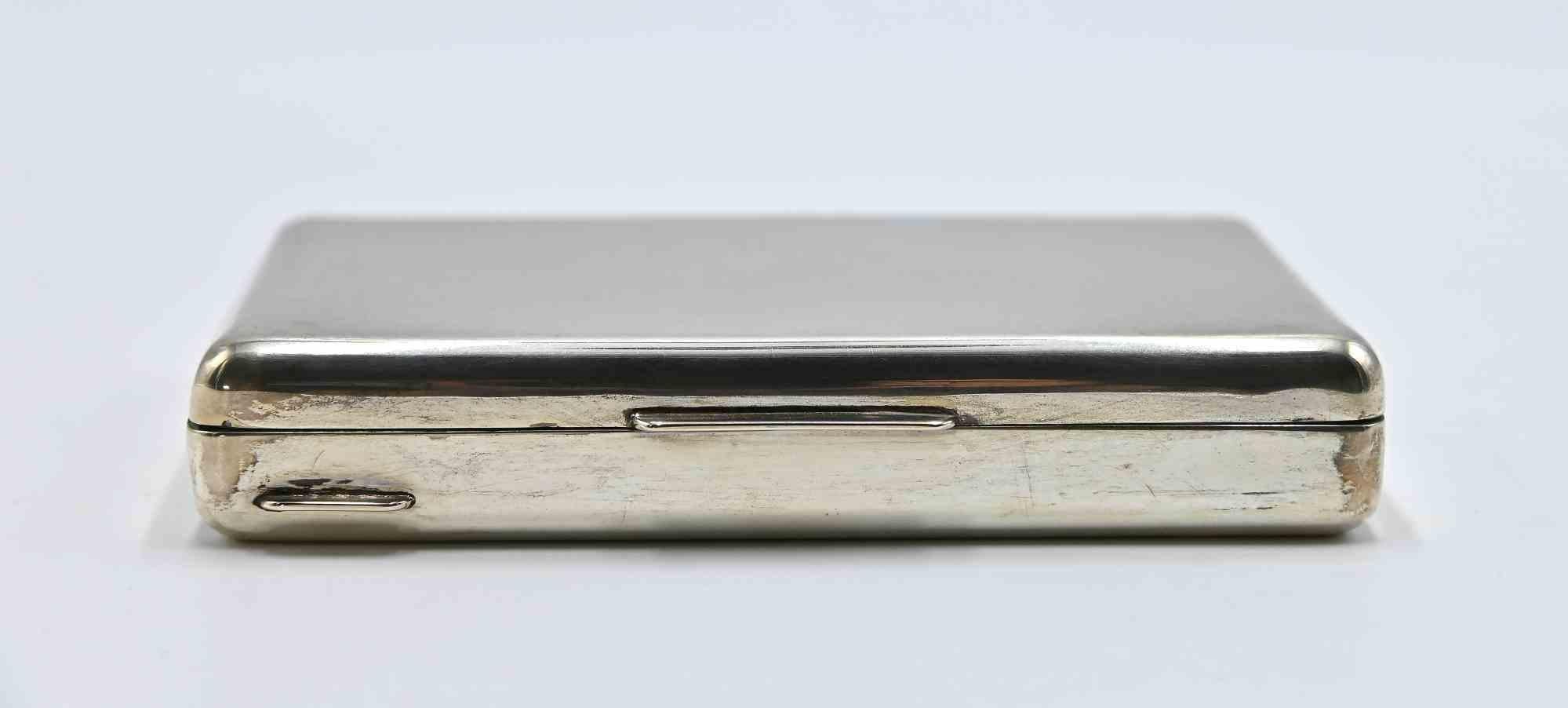 A sleek and refined cigarette case crafted in solid silver, realized in the 1960s, showcasing a smooth polished surface with softly rounded edges and a minimalist aesthetic.

The rectangular form opens on a sturdy concealed hinge, revealing a clean,