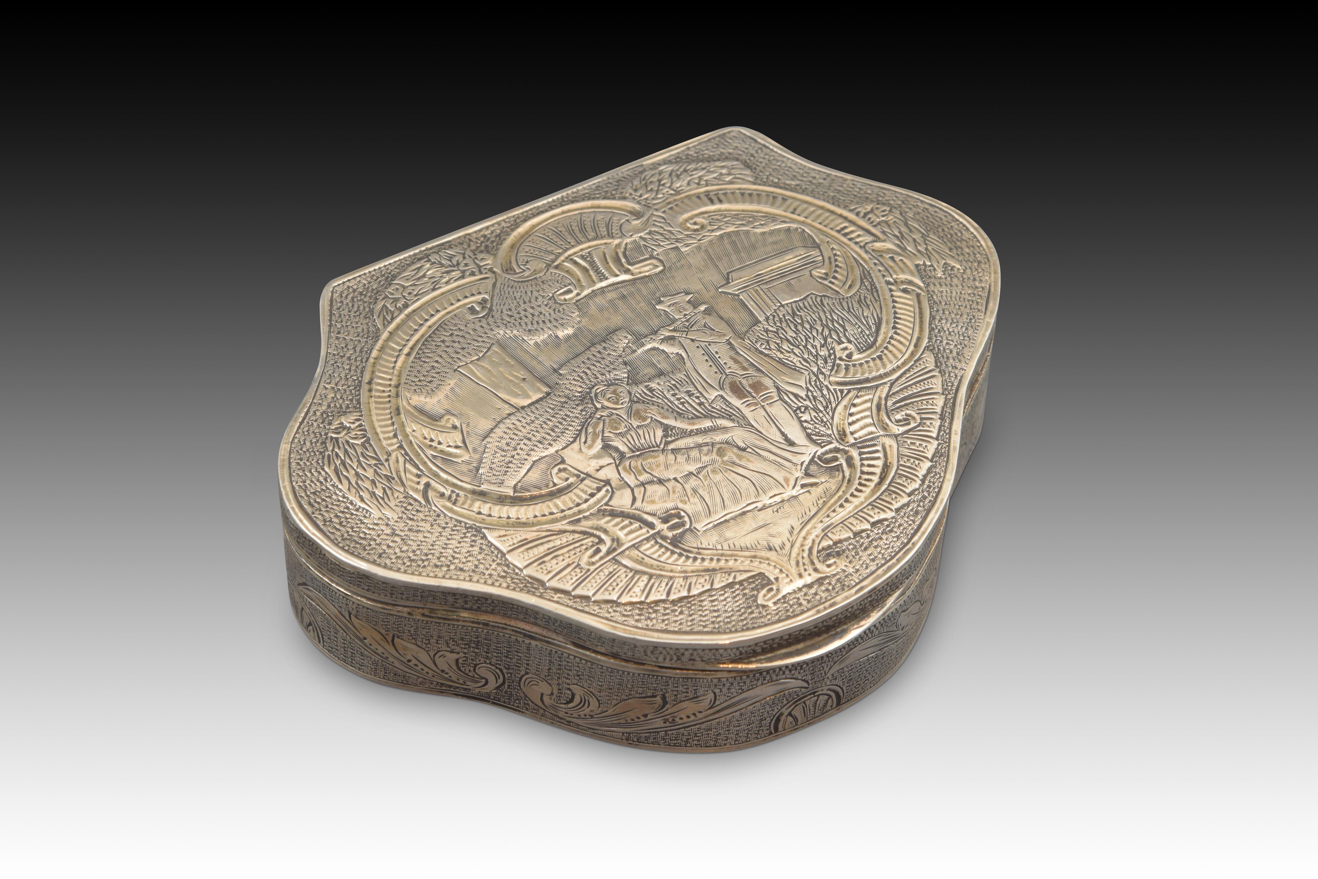 With hallmarks.
Three-lobed flat-top box made of silver in its color decorated on the edge and lid with elements on chopped luster. The upper part presents a scene framed by scallops and elements reminiscent of Rococo, starring a couple located in