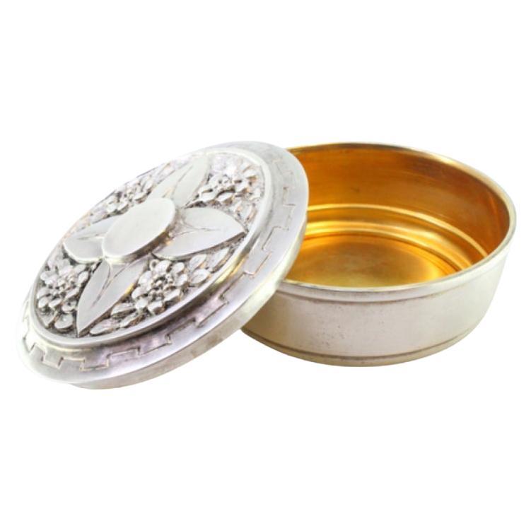 Silver box for hosts with raised floral motifs on the lid and gold interior