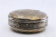 Silver box for rosary in circular shape with scrolls, flowers and angel figure