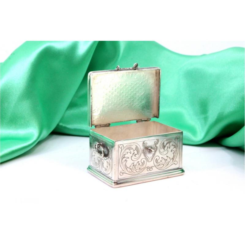 Description: Silver box in the shape of a chest with reliefs and applications with a hinged lid. Metal: Silver. Origin: Portuguese. Mark: standing eagle. Weight: 78.84 grams. Dimensions: 5.5cmx3.5cm. Content: 833/1000. Assay Mark: Yes, between 1938
