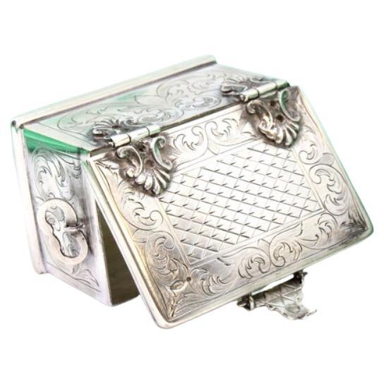 Silver box in the shape of a chest w/ reliefs & applications w/ a hinged lid