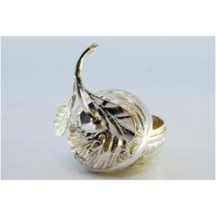 Silver box in the shape of a fruit with reliefs and leaf applications