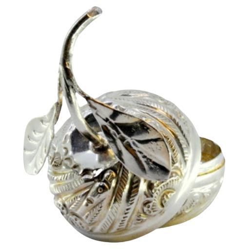 Silver box in the shape of a fruit with reliefs and leaf applications