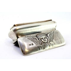 Silver box w/ an angel embossed on the lid & interior lined w/ purple velvet