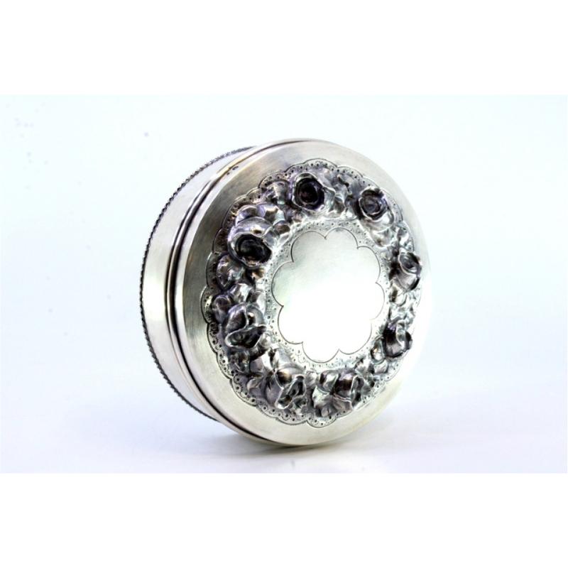 20th Century Silver box w/ raised floral motifs & a surrounding frieze on the circular base For Sale