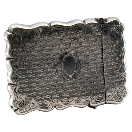 Silberne Schachtel mit Gravuren rund um die Monogrammkarte und wellenförmigem Rand im Angebot