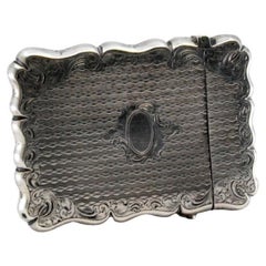 Silberne Schachtel mit Gravuren rund um die Monogrammkarte und wellenförmigem Rand Silberne Schachtel mit Gravuren rund um die Monogrammkarte und wellenförmigem Rand