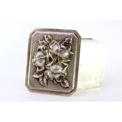 Silver box with flowers in high relief on the removable lid and gold interior