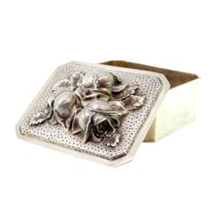 Silver box with flowers in high relief on the removable lid and gold interior