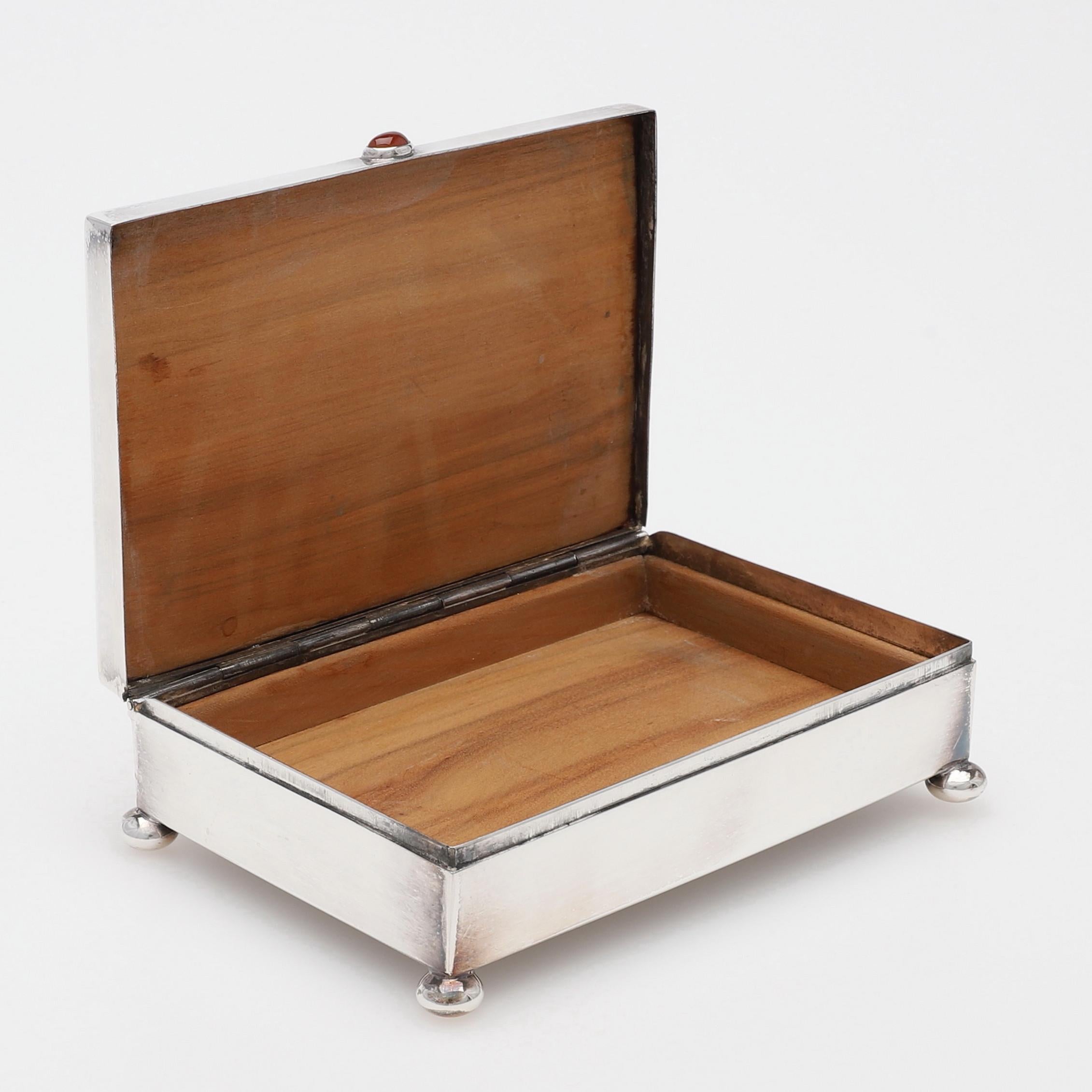 Eine silberne Schachtel mit  mit rotem Stein auf dem Deckel  , innen Zedernholz, Höhe ca. 4 cm, Länge ca. 12,5x8,5cm. Markiert 