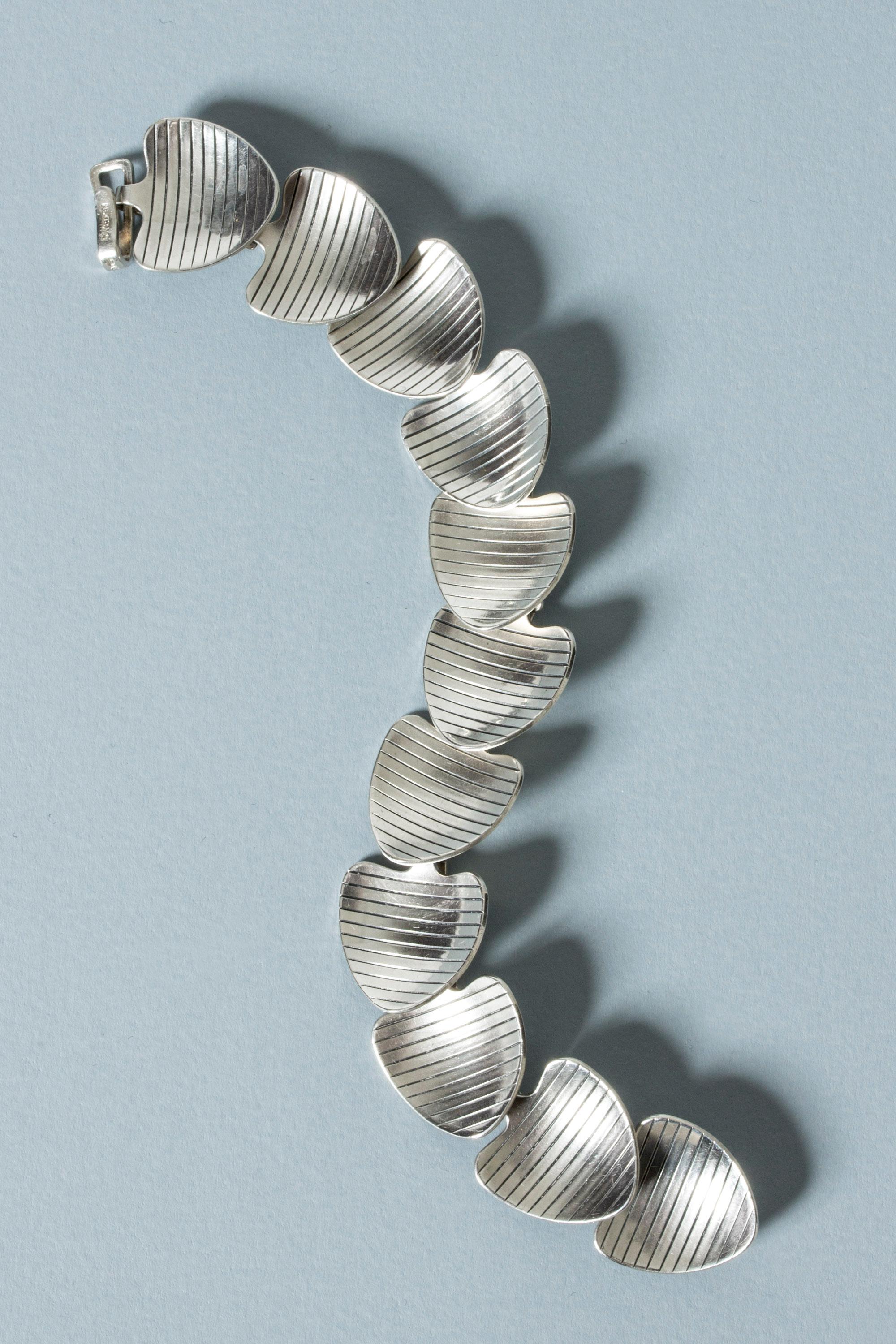 Elegant silver bracelet from Atelier Borgila, made from slightly concave segments in the form of stylized leaves. Decorative stripes.

