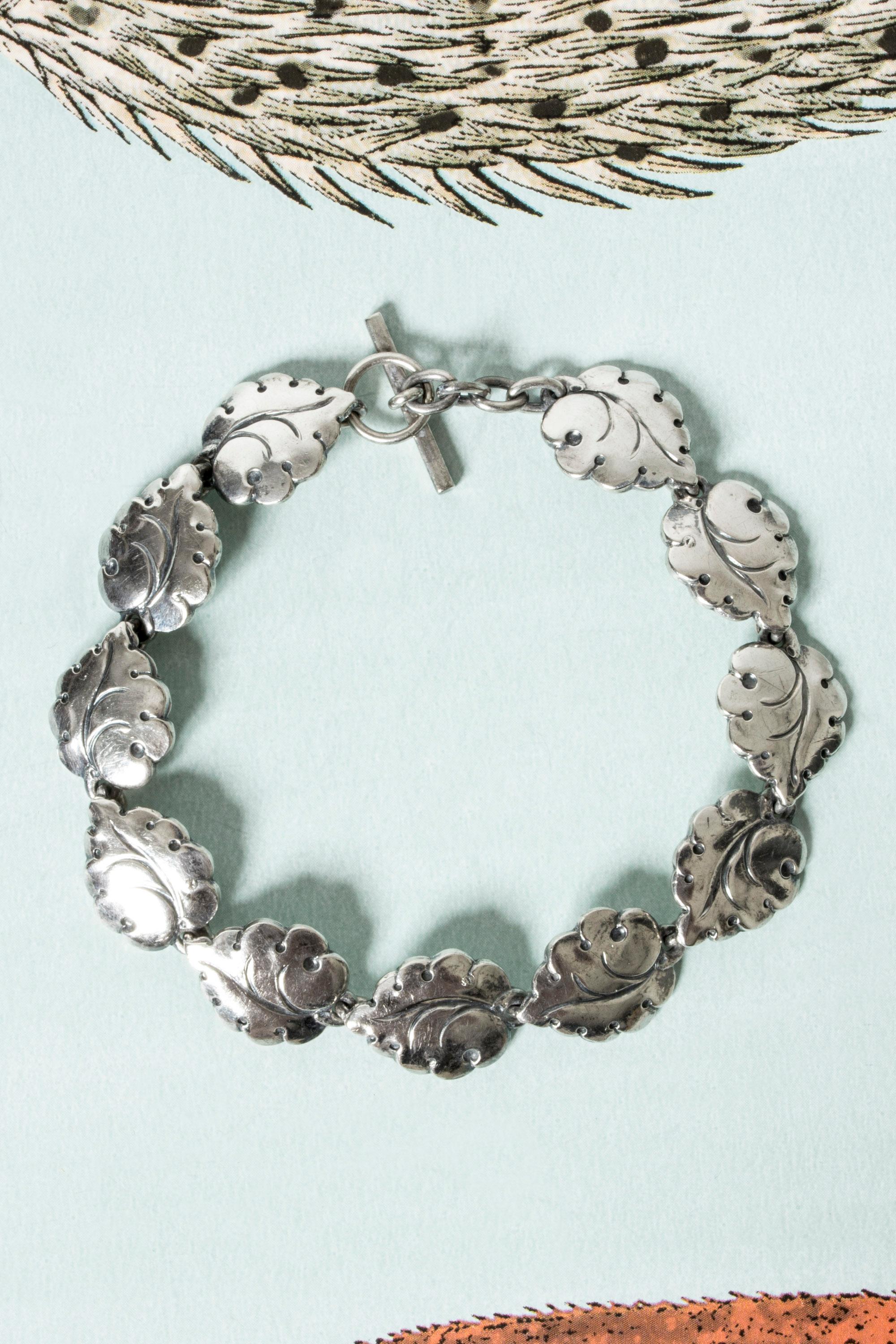Joli bracelet en argent de Hugo Grün, avec des maillons en forme de feuilles. Très belle attention aux détails, élégant et léger au poignet.