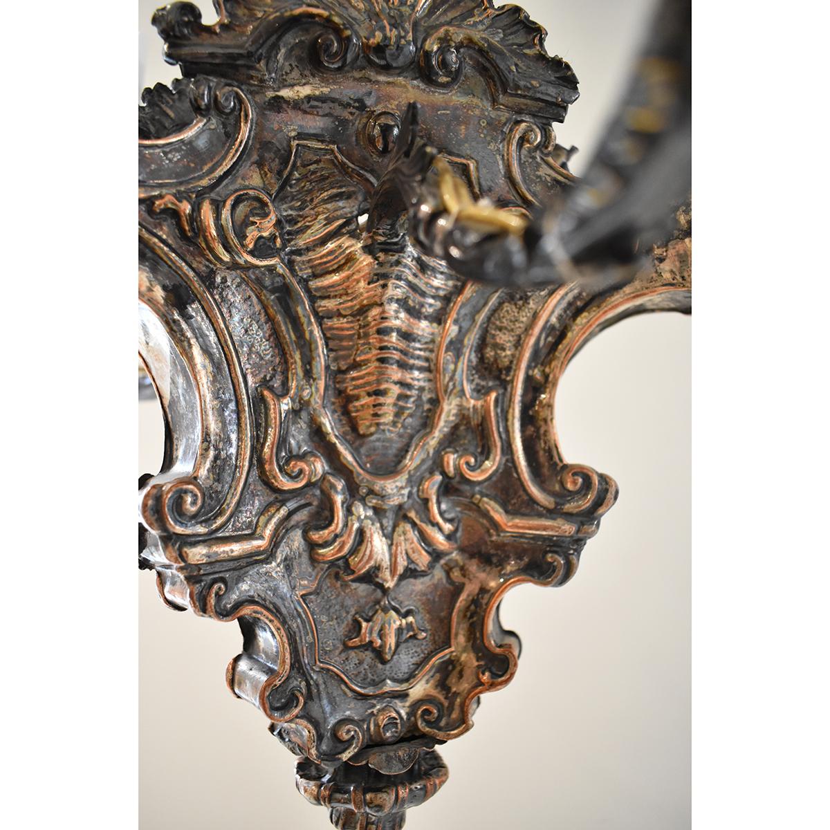 Lampadario unico in argento placcato in ottone. Con tre bracci e catena ornata, l'apparecchio ha anche un baldacchino abbinato. All'interno dell'apparecchio c'è una presa per la luce che creerebbe un attraente effetto di illuminazione verso l'alto.