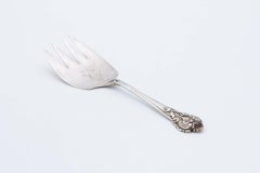 Silver bread serving fork with reliefs on the handle and engraved floral motifs