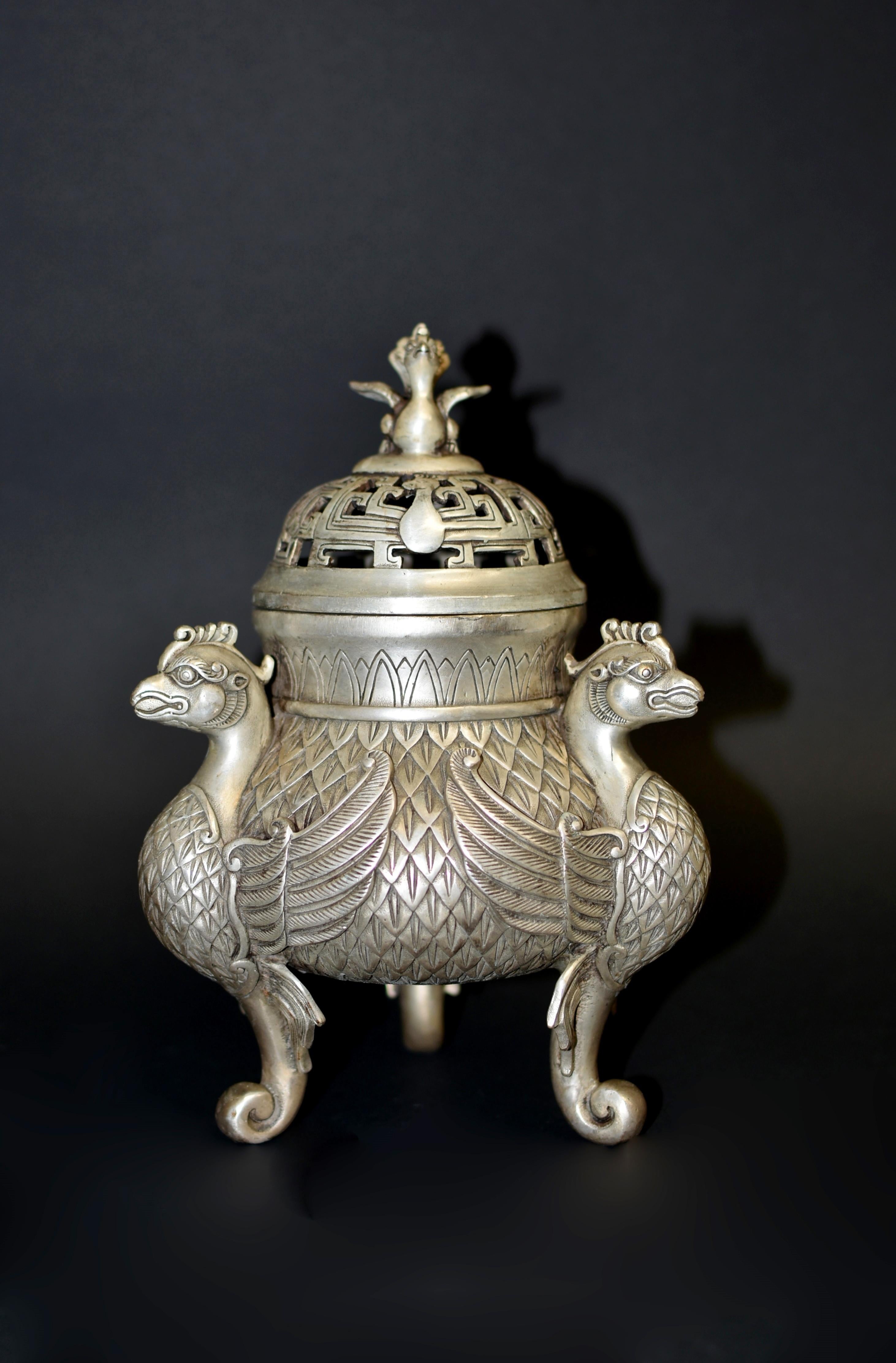 Un magnifique encensoir tripode en bronze argenté de 4 livres. Le récipient est décoré sur les côtés bulbeux de trois faisans royaux sur un fond de plumes texturées, sous un grand couvercle percé d'un motif d'éternité, surmonté d'un jeune faisan