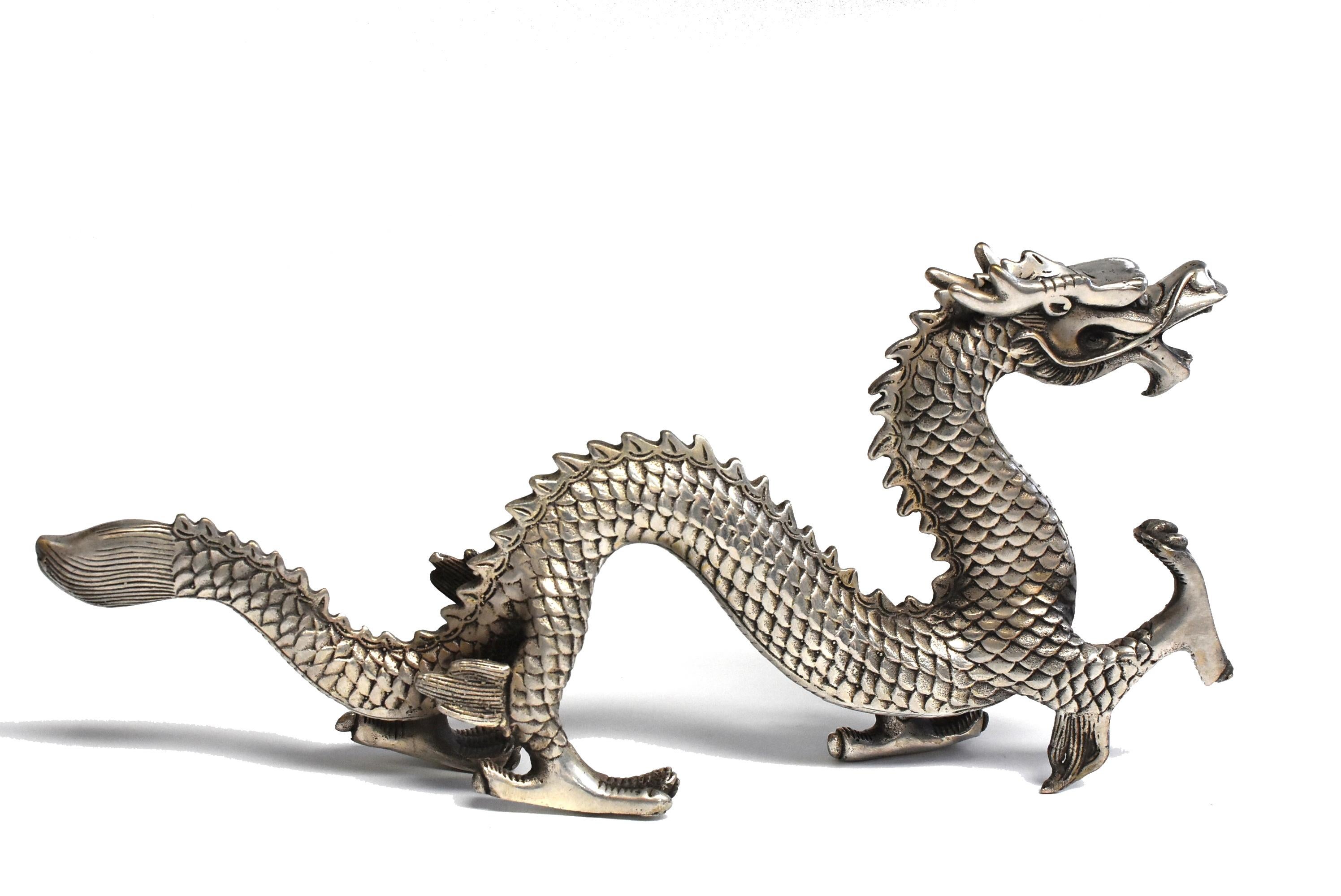 This model of dragon is a fine example of animal sculptures in the late Qing dynasty style. The four-clawed dragon has one front talon in pursuit of its subject, likely a flaming pearl, while the other three are firmly planted on the ground. The