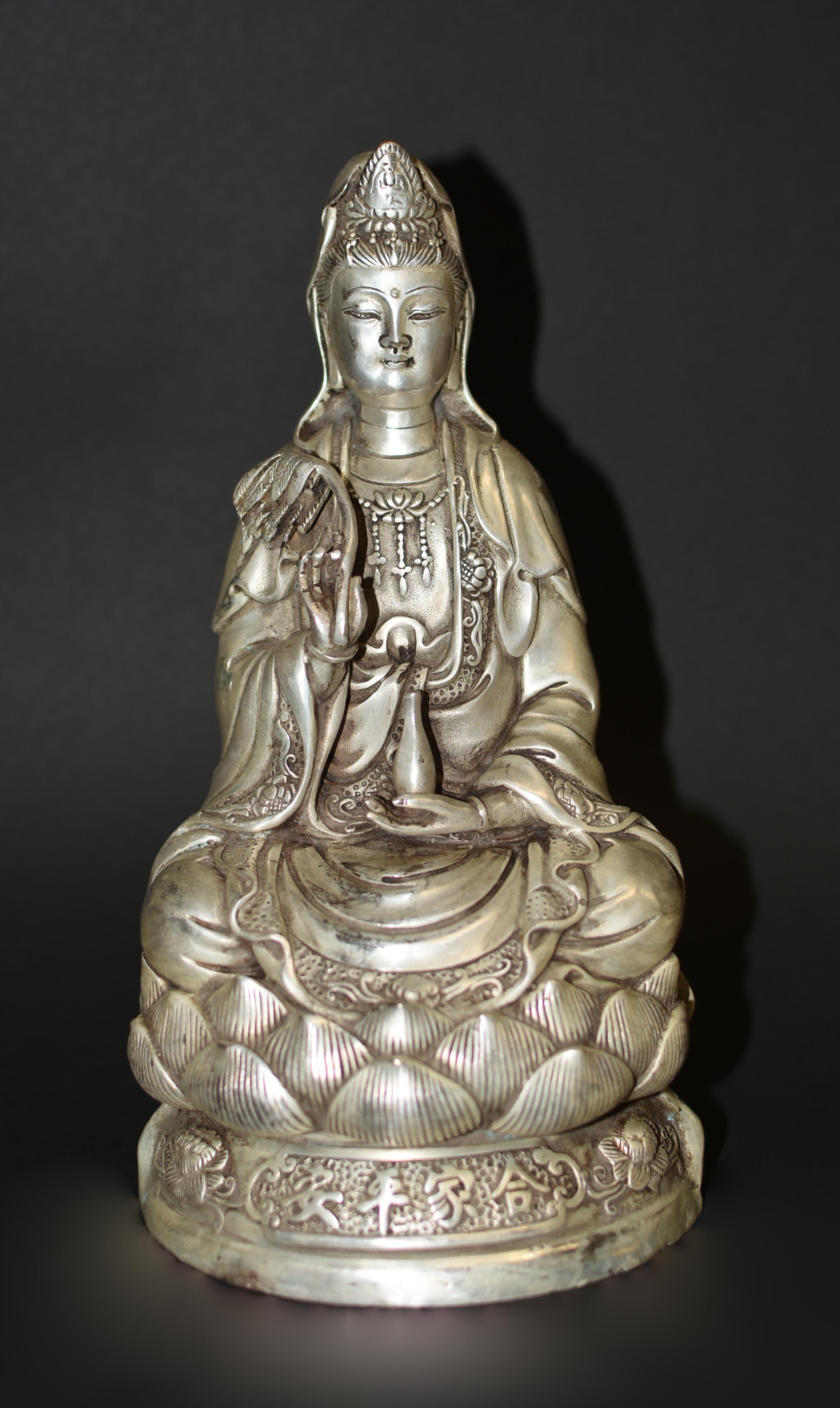A large 7.15 lb Republic era silver bronze statue of the Goddess of Compassion Guan Yin. Seated on lotus throne, Bodhisattva Avalokiteshvara is depicted in the most traditional fashion. The Tang style face is broad and serene, with downcast eyes