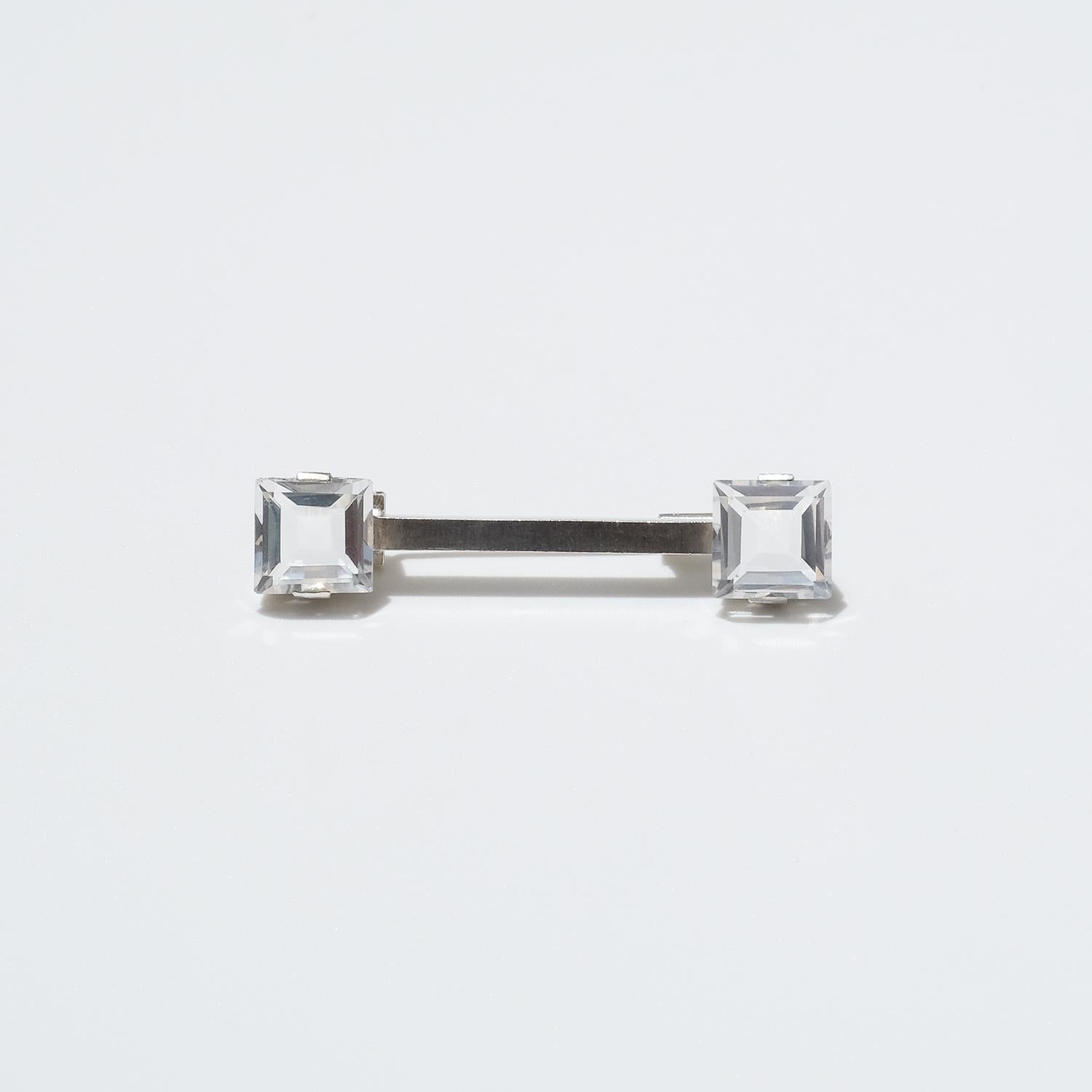 This silver brooch is adorned with one faceted rock crystal on each end. It is fastened easily with a trombone clasp, which were commonly used in jewelery made in the 1940s.

The brooch has a classic look making it available for both a he or a she,