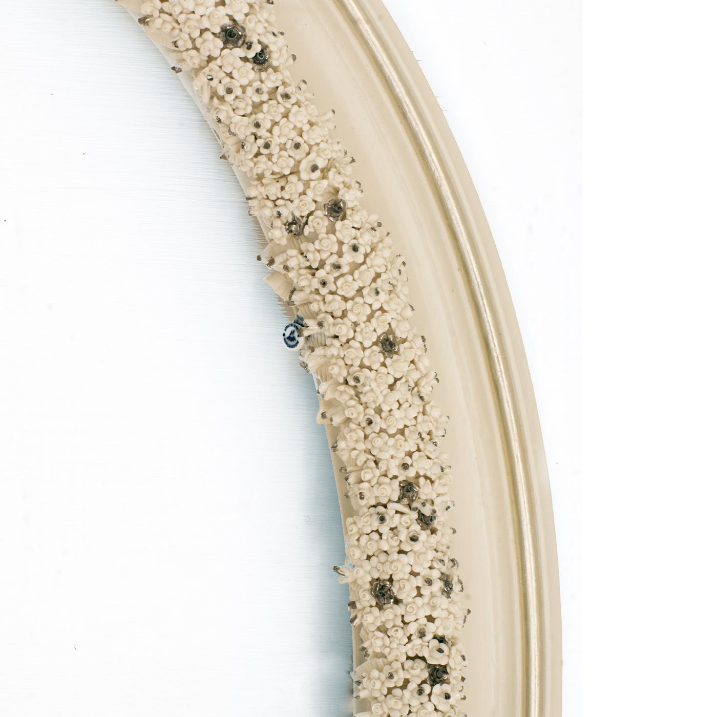 This stupendous oval wall mirror is a unique, exclusive design of unprecedented charm that will add refinement and sophistication to any style decor. Crafted of MDF lacquered in an ivory shade, it is finished with silver leaf details and elegant