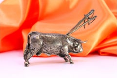 Silver bull with a profusely defined figure and four swords on its back