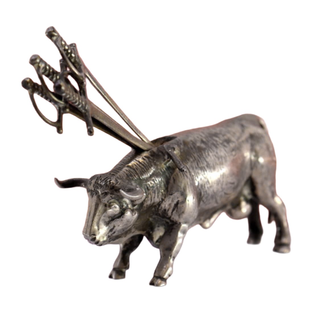 Silver bull with a profusely defined figure and four swords on its back