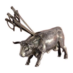 Silver bull with a profusely defined figure and four swords on its back