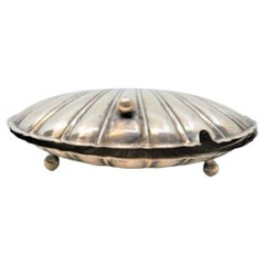 Silver butter dish in the shape of a double shell and resting on three feet