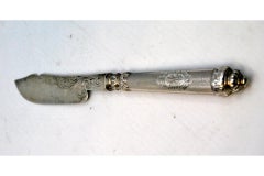 Silver butter knife with engraving on the blade and perforation on the handle