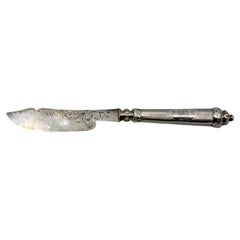 Silver butter knife with engraving on the blade and perforation on the handle