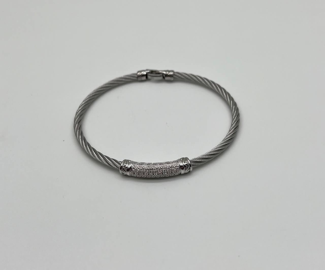 Fabriqué en acier argenté élégant, ce bracelet contemporain présente un câble torsadé. La pièce maîtresse est un or blanc 18 carats incrusté de diamants pavés étincelants, ajoutant une touche d'élégance. Le fermoir sécurisé assure un ajustement