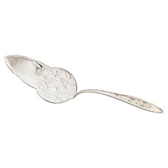 Silver cake serving spatula with reliefs and a handle with filigree applications