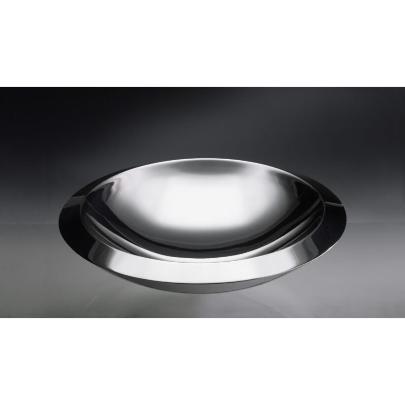 Plat de service Caldafreddo en argent par Angelo Alinea
Dimensions : D 38 x H 9 cm 
Matière : Argent.

Cet objet a été conçu comme un volume, formé par la combinaison de deux feuilles moulées qui ont été soudées l'une à l'autre. L'espace creux entre