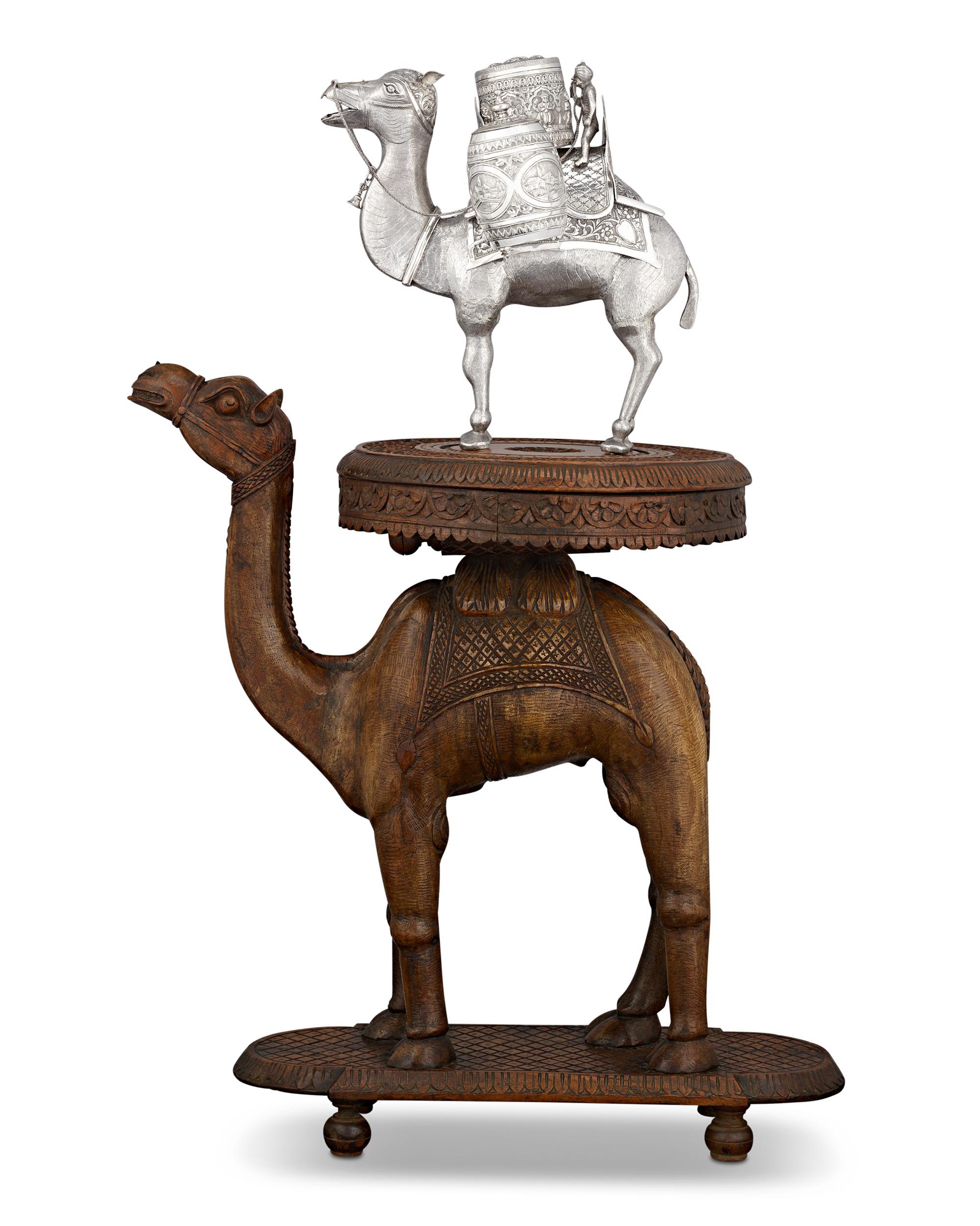 Silberne Kamel-Teekanne und geschnitzter Tisch
CIRCA 1880

Diese bemerkenswerte Teedose aus indischem Silberkamel mit dem passenden geschnitzten Holzsockel repräsentiert den Höhepunkt der indischen Handwerkskunst des 19. Dieses phantasievolle