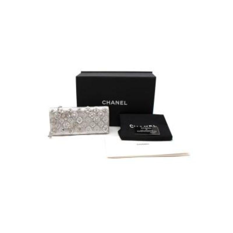 Chanel Silber Kamelie verschönert Kette Clutch
 
 - Weicher, genarbter Lederkorpus in einem schönen Silberton
 - verschönert mit 3D-Kamelien 
 - Silberfarbene Hardware
 - Kann als Clutch oder über der Schulter getragen werden
 - Lang strukturierte
