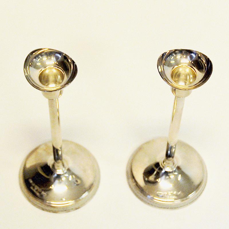 Midcentury silver candle light pair designed by Ainar Axelsson for GAB, Sweden, 1967. Beautiful, clean and Classic pair of vintage candlesticks with a nicely sculpted top. Decorated bottom edge.
Signed and stamped on the bottom front. Good vintage