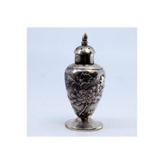 Candelero de plata de origen asiático, profusamente decorado con relieves florales