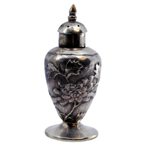 Silver candlestick of Asian origin, profusely decorated with floral reliefs For Sale