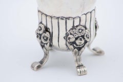 Silver candlestick with floral motifs, bows and four raised engraved feet