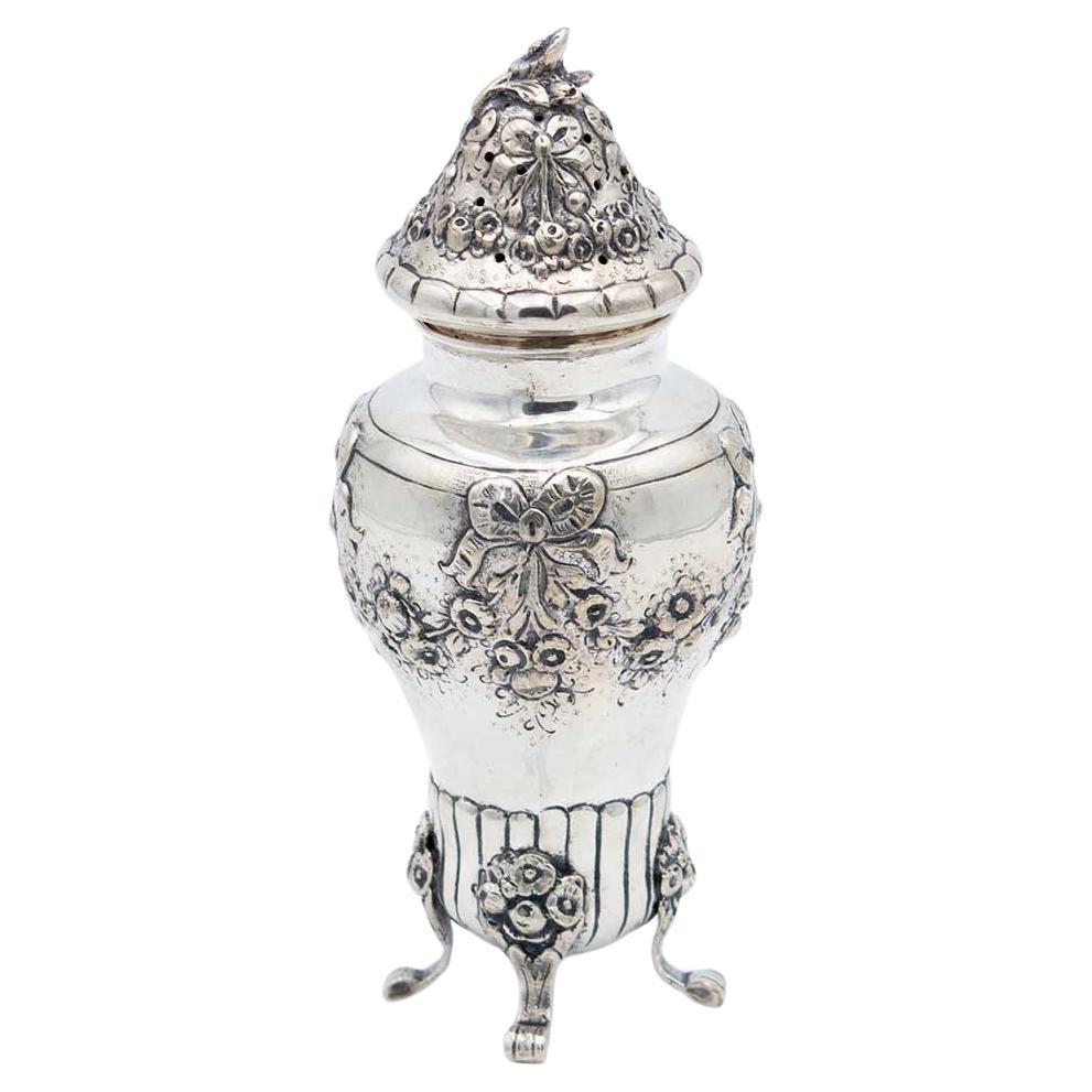 Silver candlestick with floral motifs, bows and four raised engraved feet