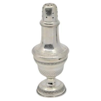 Silver candlestick with friezes around the edges and set on a circular base