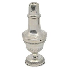 Silver candlestick with friezes around the edges and set on a circular base