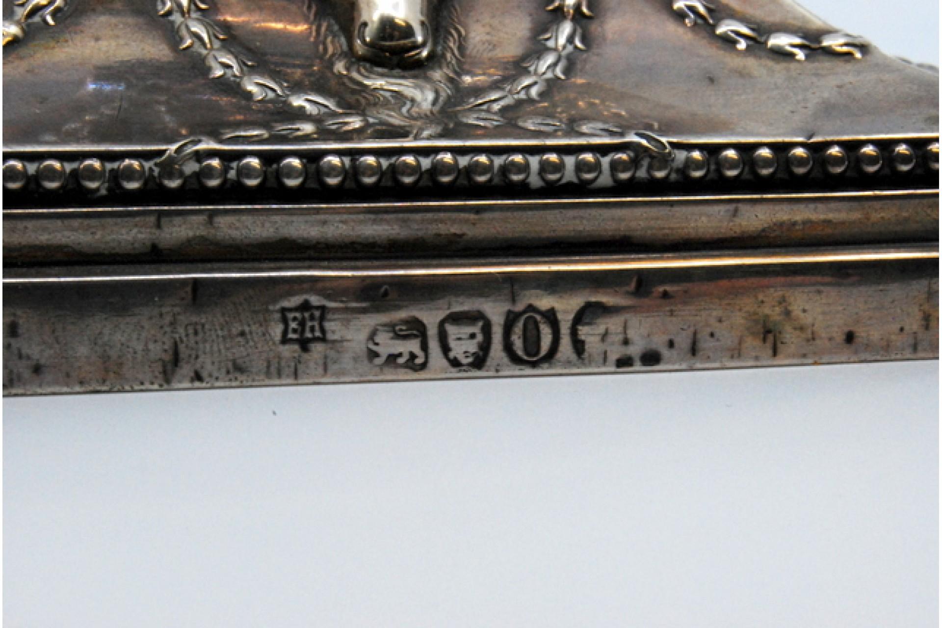 Description: Silver candlestick with rope windings on the shaft and ram's heads in relief on the square base. Metal: Silver. Origin: English. Brand: London. Weight: 1305.72 grams. Dimensions: 31x12.2cm. Content: 925/1000. Assay Mark: Yes, 1889.