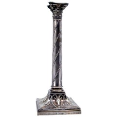 Silver candlestick with rope-wound shaft and ram heads on square base