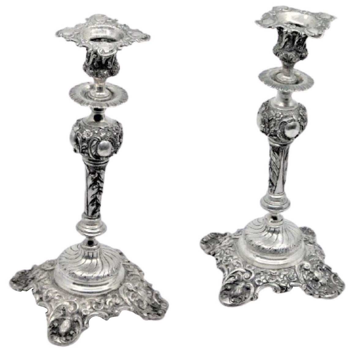 Silver candlesticks embossed w/ floral motifs 
scrolls, sconces 
cut-out bases