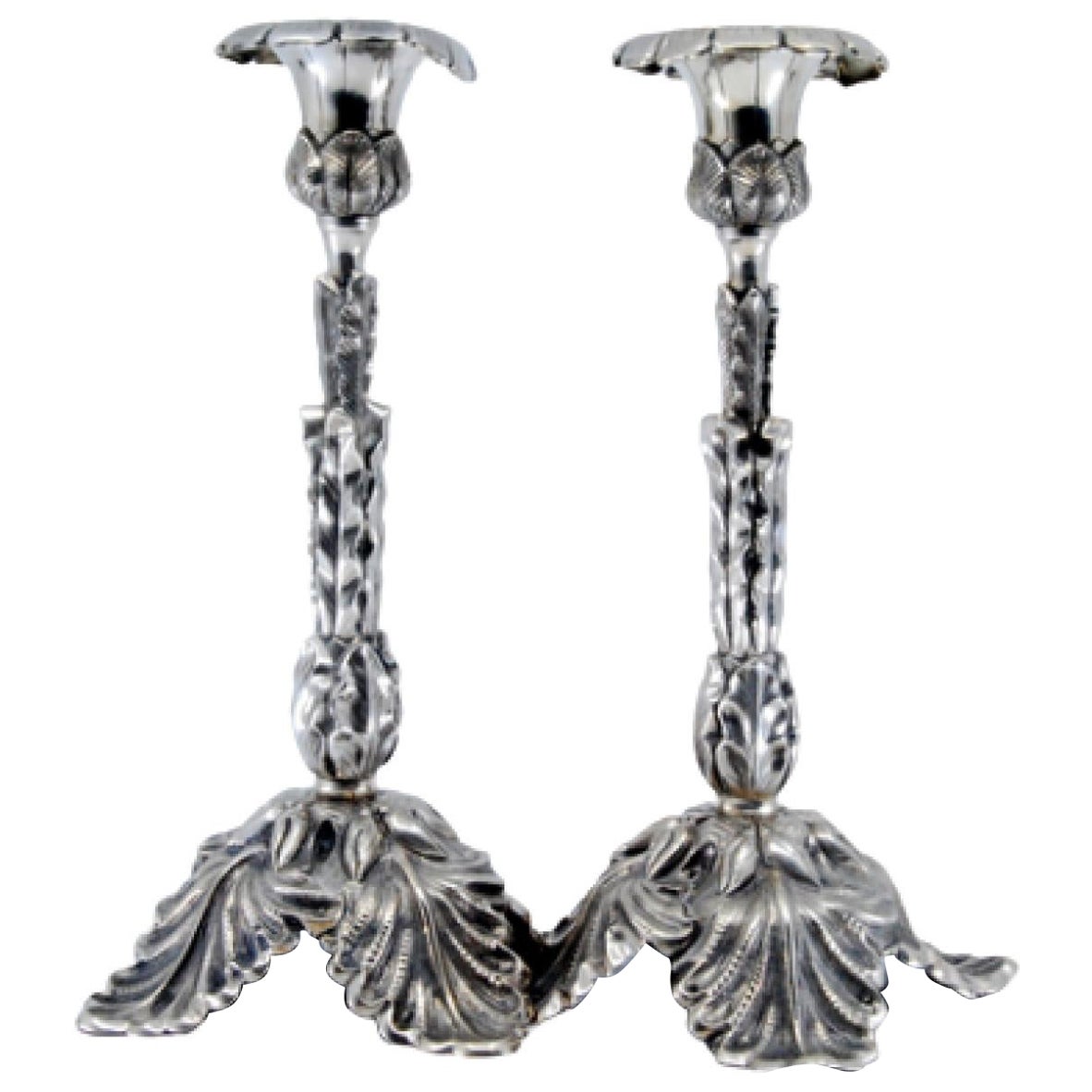 Silver candlesticks embossed with acanthus leaves and resting on three feet