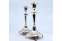 Candelieri in argento con scanalature che poggiano su basi circolari con quattro piedini tagliati.