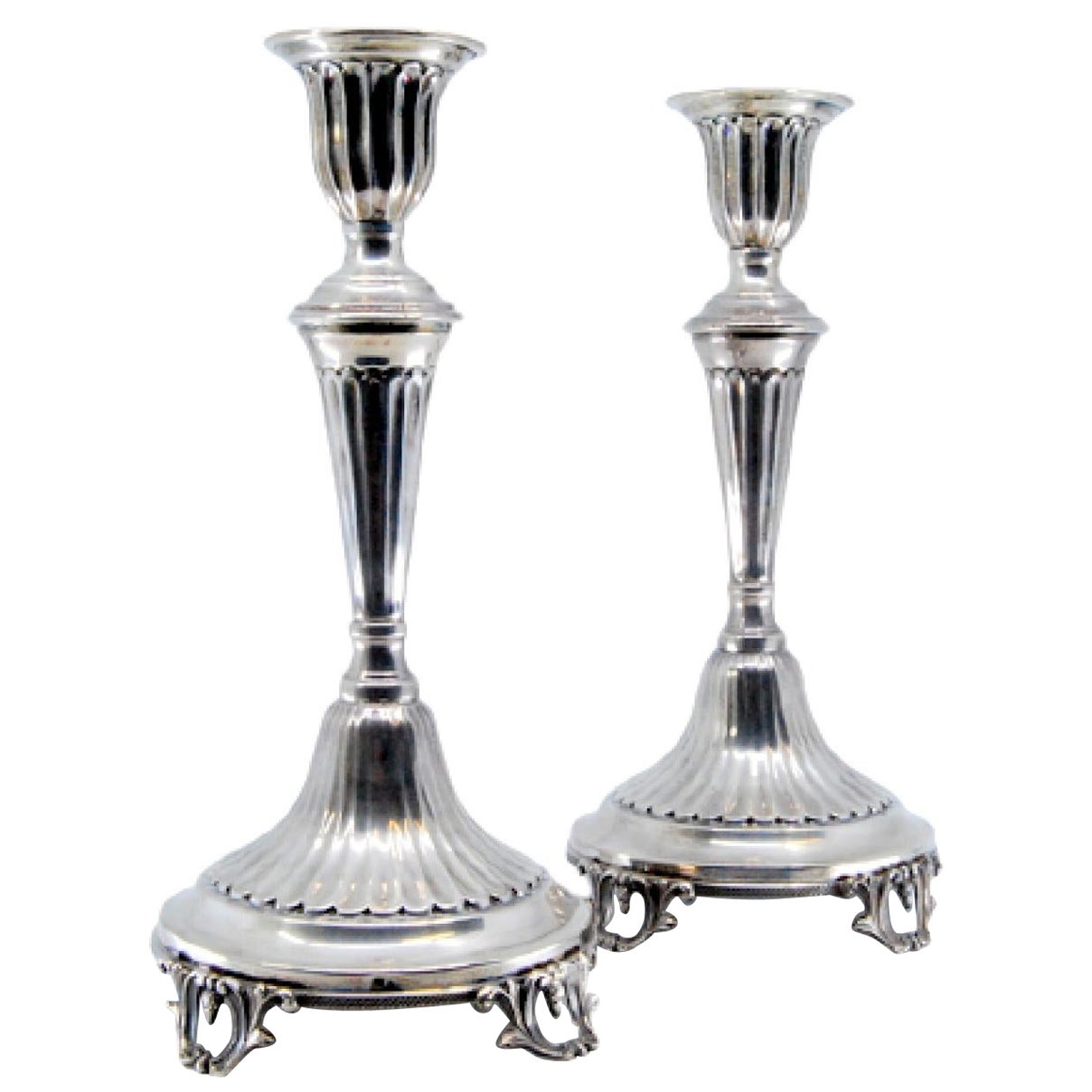 Silver candlesticks w/ fluting resting on circular bases w/ four cut-out feet
